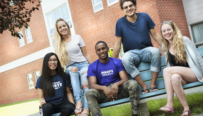 Bishop's students smile at the camera on the sunny campus.