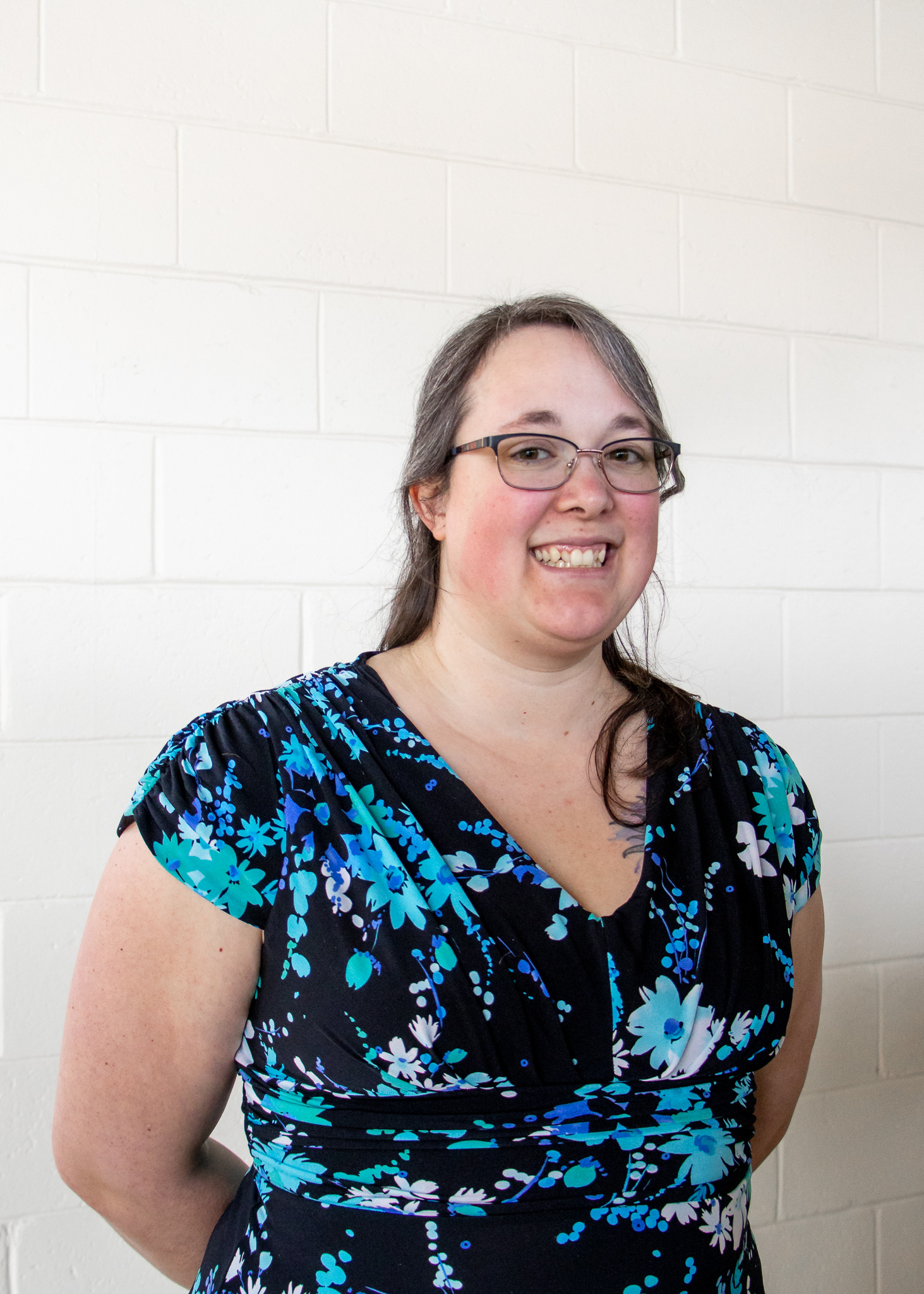 A photo of a young woman with glasses in front of a white wall. She is Anne-Marie Viens-Larin.