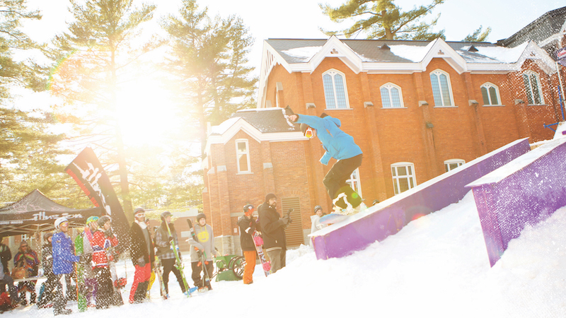 Bishop's students cheer in their winter gear during the snowboarding competition of WinterFest, the yearly winter-themed festival held on the Bishop's quad.