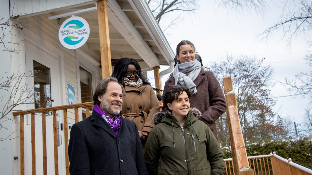 Four people standing outside the new Sexual Violence Support Centre. They're smiling off camera. They are Top: Danai Bélanger, Vice-Principal Student Affairs - Noémie Thibault, Sexual Violence Response Advisor
Bottom: Dr. Sébastien Lebel-Grenier, Principal - Gabrielle Joncas-Brunet, Sexual Violence Response Advisor