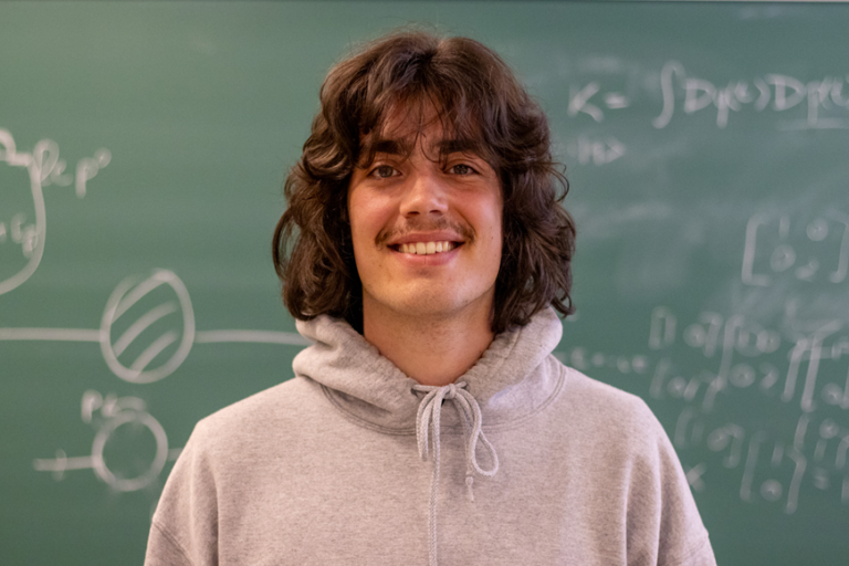 John Grace in front of a chalkboard.
