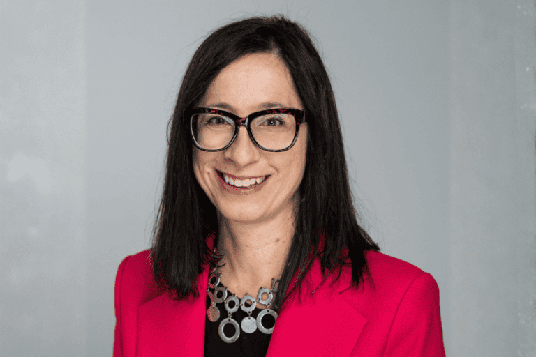 Dr. Linda Morra in front of a a grey background.