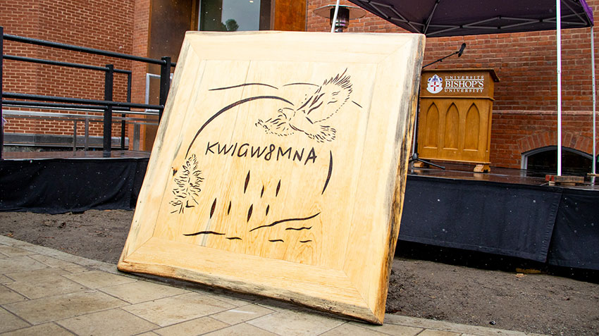 Logo of Kwigw8mna on wood.