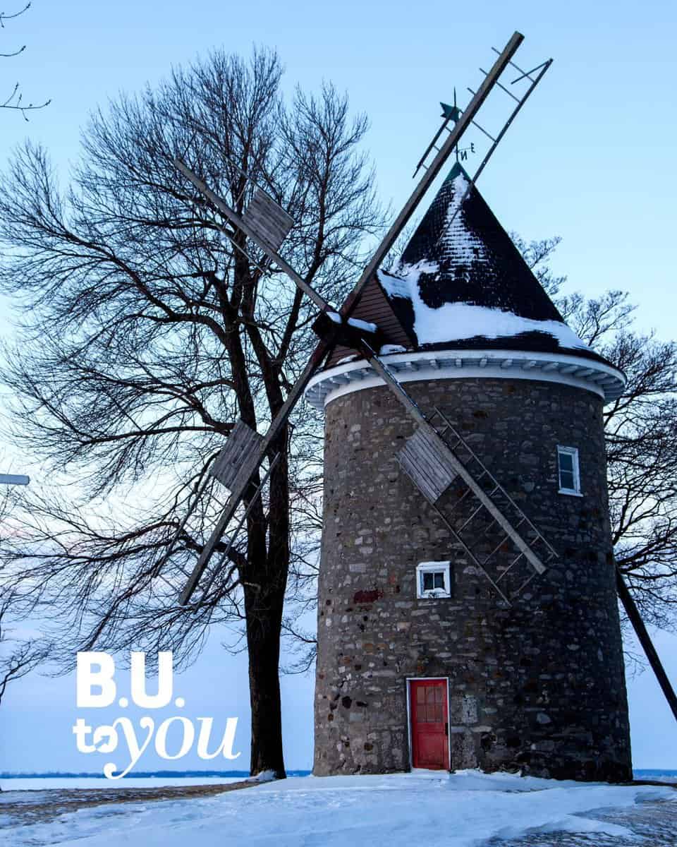 Landscape photo of windmill in Pointe-Claire with the B.U. to You logo