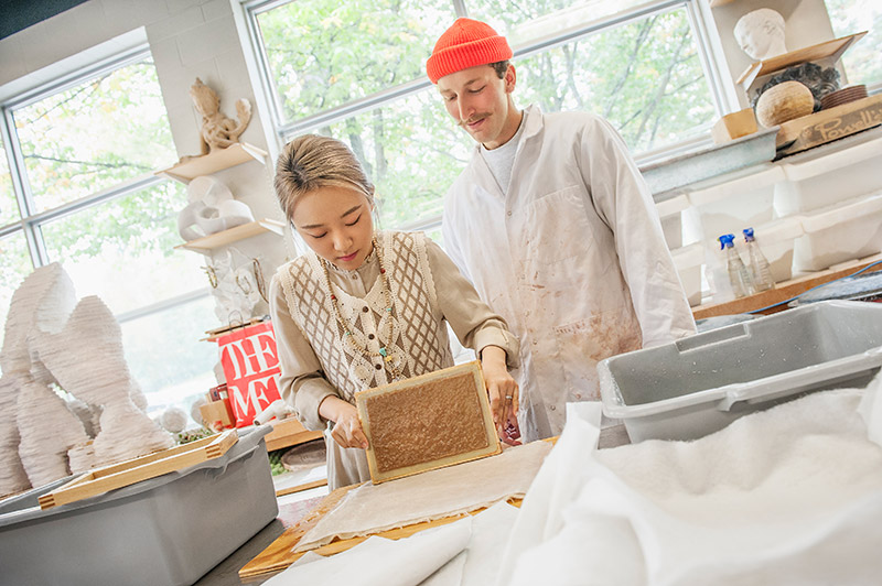 Fine arts students working with paper