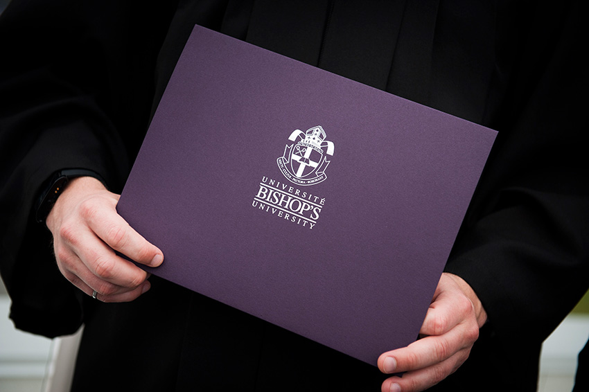 A student holding his diploma.
