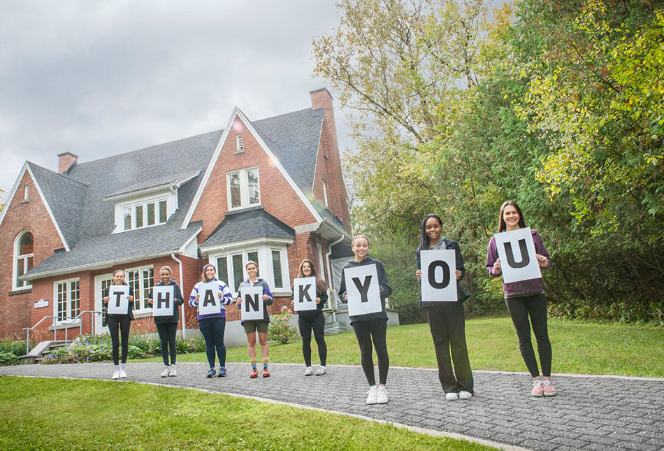 Students holding signs spelling Thank You.