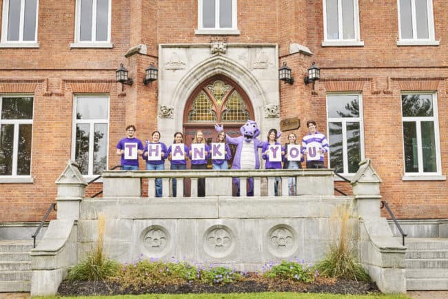 Students holding thank you signs in front of McGreer